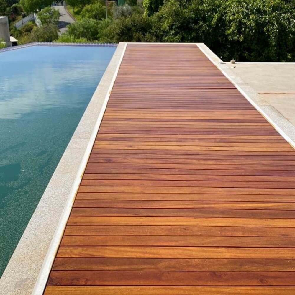 Deck Cumaru Extra 10cm - Peças de 1,80m utilizado com deck de piscina de borda infinita, um contraste espetacular.